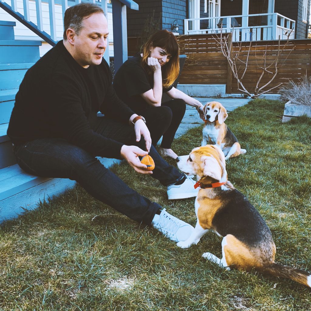 Jenn and Nic Hepton sit on their porch stairs with two dogs