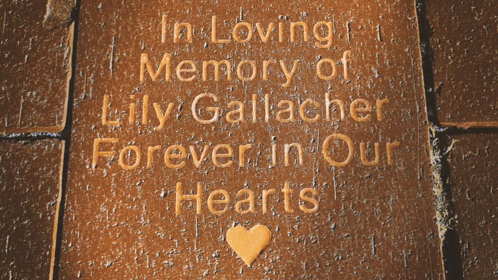 A memorial brick reads In loving memory of Lily Gallacher, Forever in Our Hearts